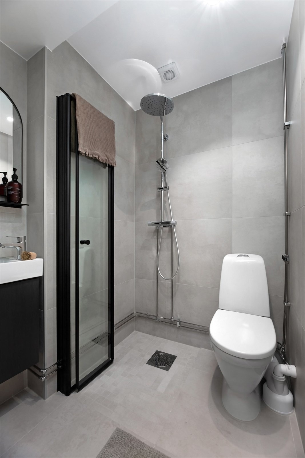 Moderne bad med svart innredning og grå fliser. Galleribilde