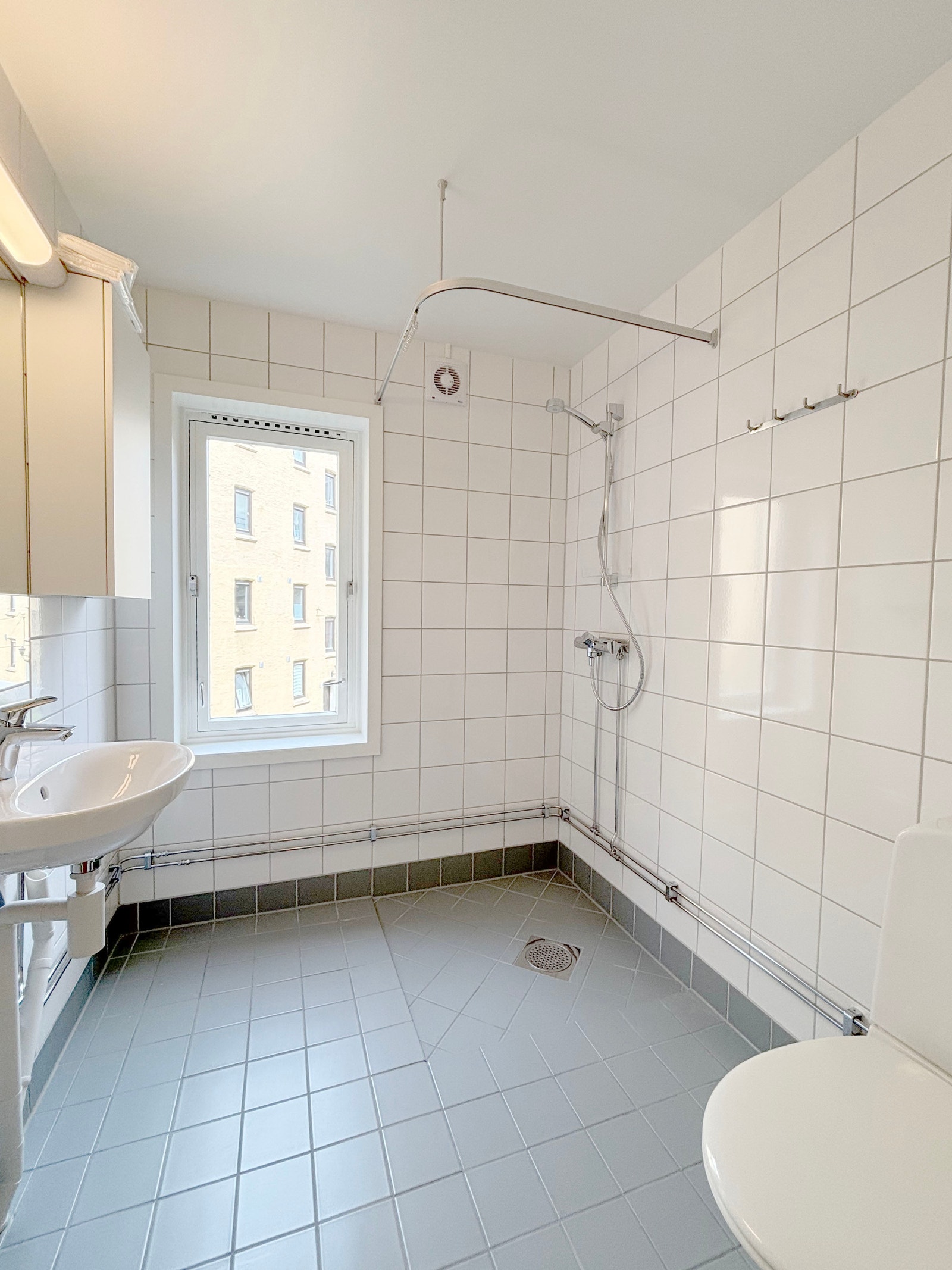 Flislagt bad med varmekabler og opplegg for vaskemaskin Galleribilde