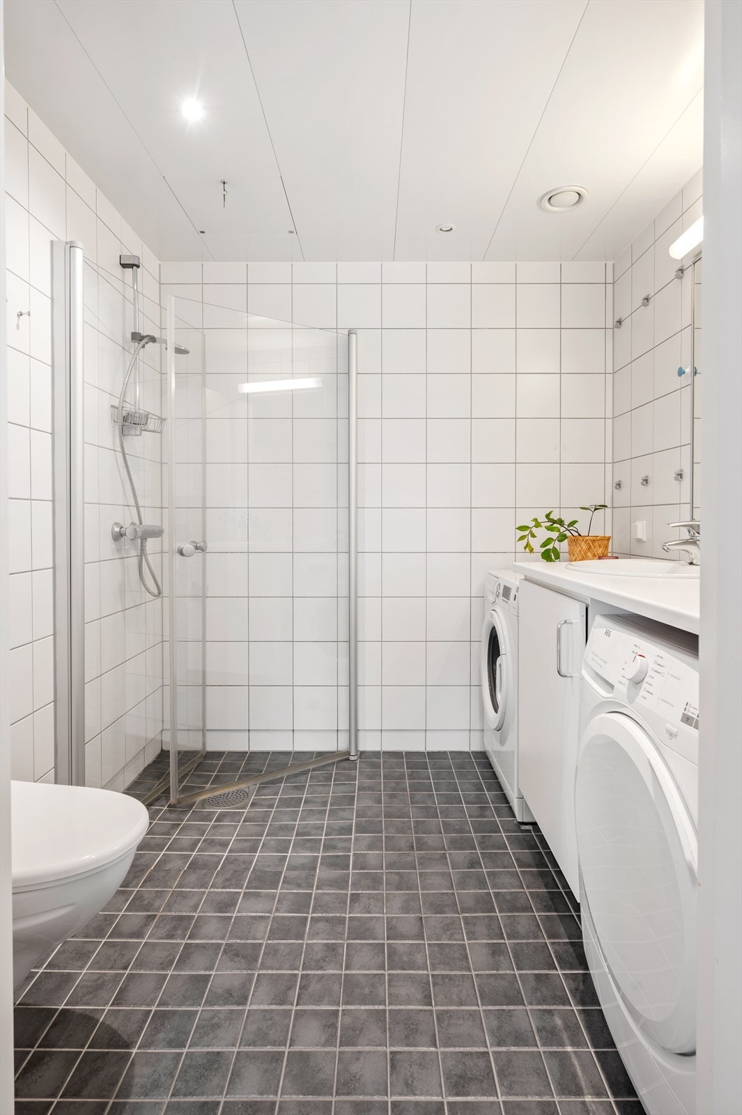 Innredningen består av vegghengt servantinnredning med benkeplate av laminat, nedfelt servant med ett-greps armatur og speil og overlys på vegg over servant. Galleribilde