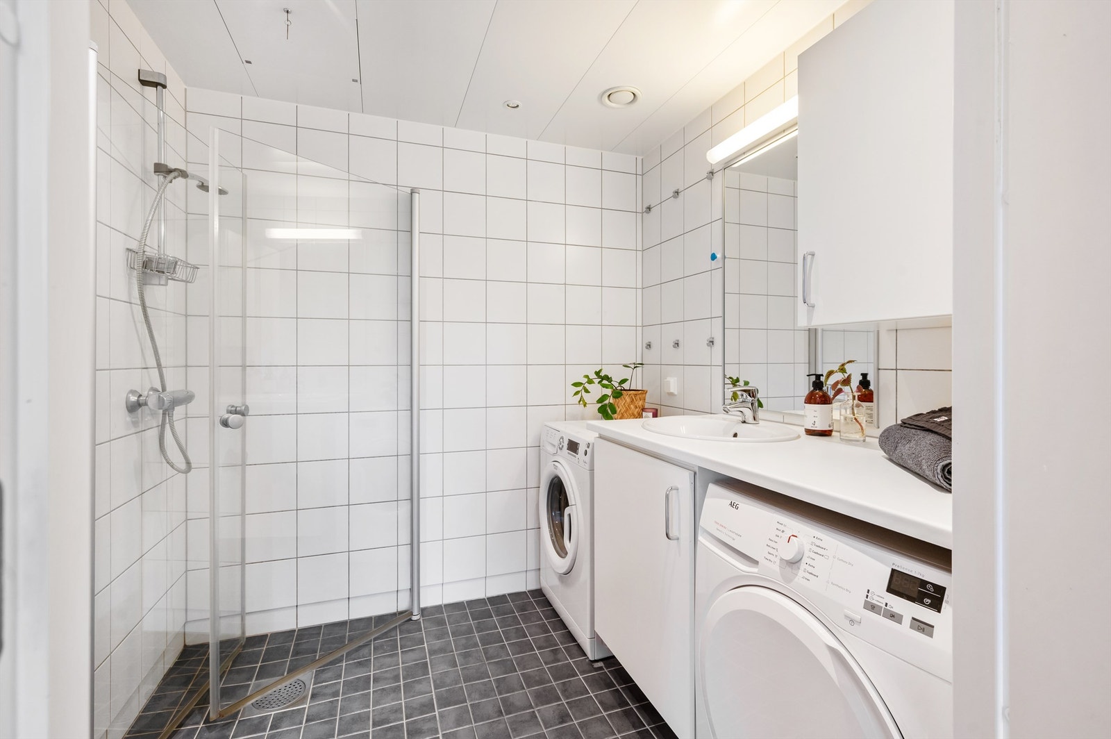 Delikat og lekkert flislagt baderom med gulvvarme og downlights i himlingen. Galleribilde