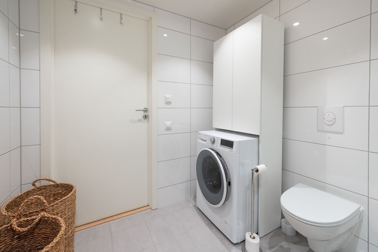 Badet har vegghengt toalett og opplegg til vaskemaskin. Galleribilde