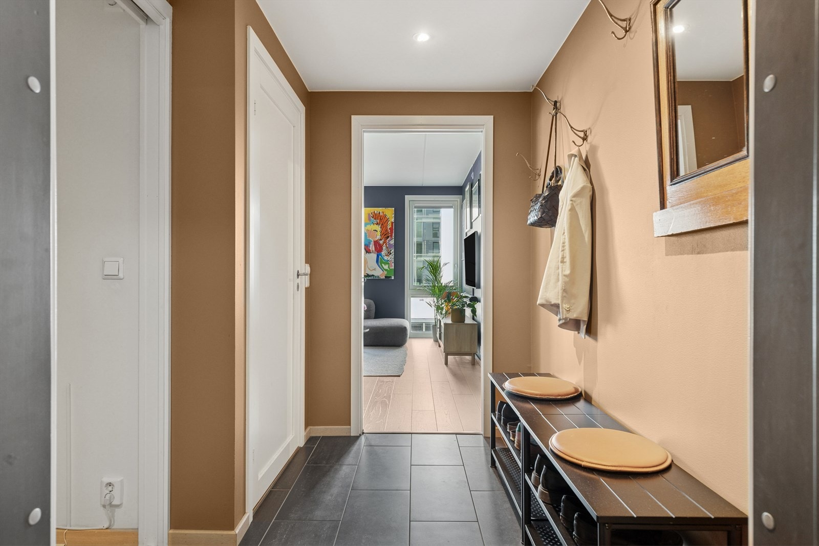 Innbydende entré med plass for ytterklær og dørtelefon med portåpner. Galleribilde