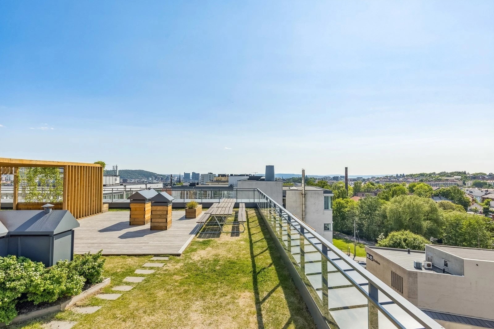 Ta heisen rett opp til en storslagen, felles takterrasse med panorama utsikt utover hele byen - Den store og frodige takterrassen oppleves som en privat park for beboerne. Galleribilde