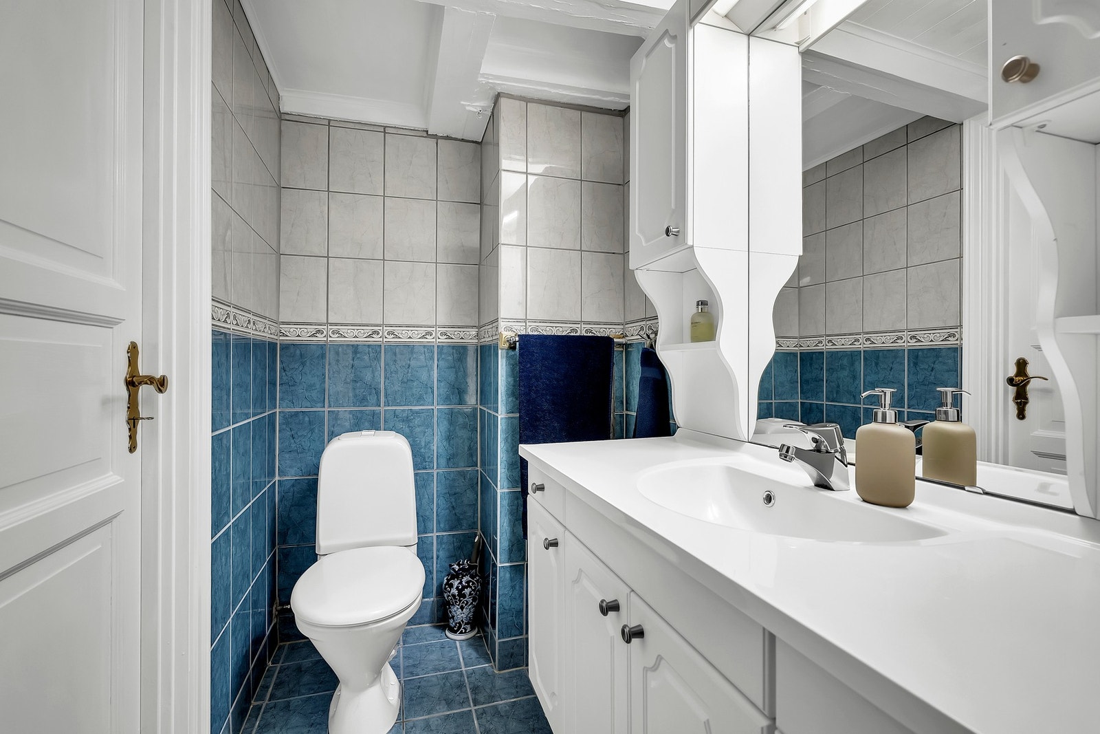 Badet har flislagte gulv og vegger, samt en himling med trepanel og synlige bjelker, noe som gir en rustikk atmosfære. Galleribilde