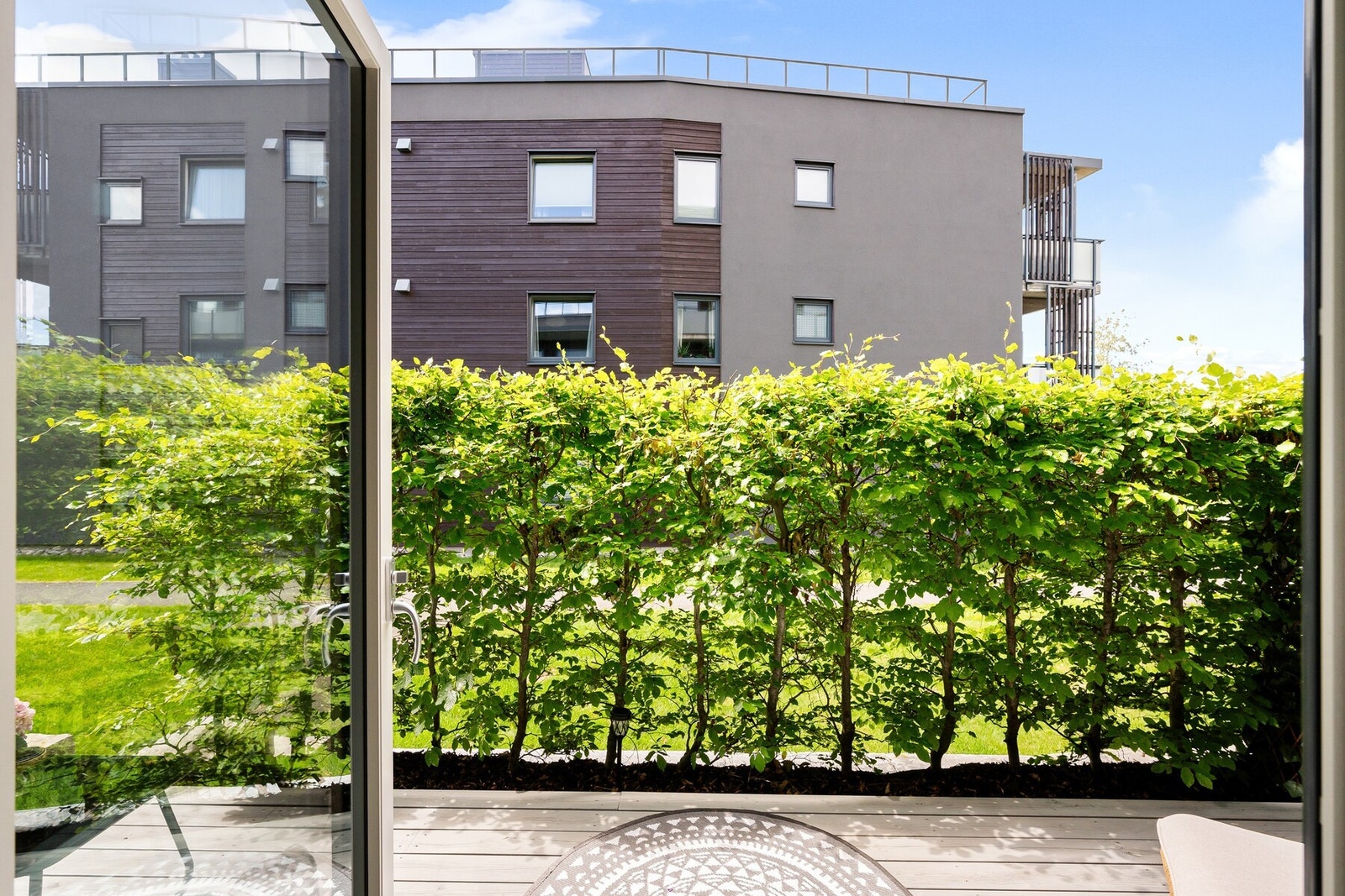 Utgang til egen markterrasse gjennom doble glassdører gir en sømløs overgang mellom inne og ute. Galleribilde