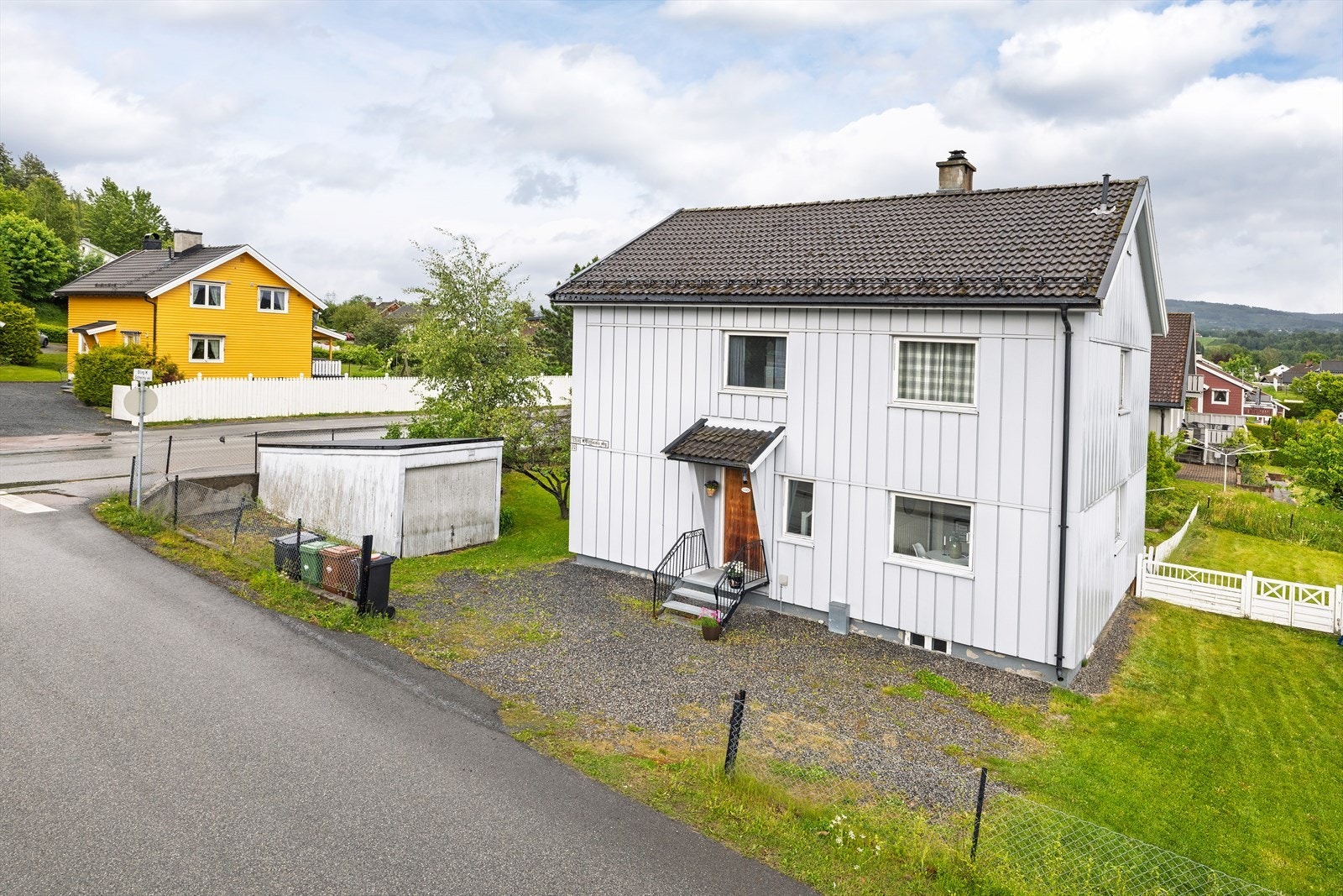Eiendommens tomt er oppdelt i to med gjerdet som grense. Til leiligheten medfølger det en liten garasje. Galleribilde