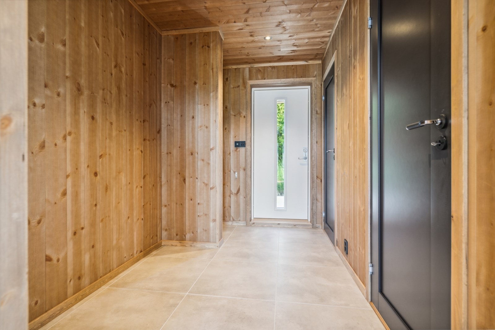 En ønskes velkommen inn i en entré hvor man får adkomst til et toalett, et vaskerom og videre adkomst til en åpen stue- og kjøkkenløsning. Galleribilde