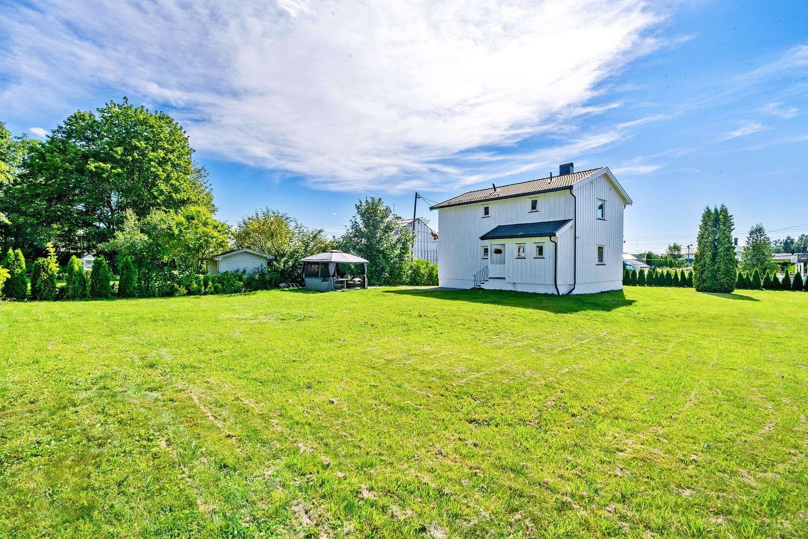 Her finner du store gressarealer, prydbusker, hekk og gjerder som rammer inn uteområdet på en tiltalende måte. Det er god plass til lek og aktivitet for både liten og stor, og tomten har svært gode solforhold gjennom dagen. Galleribilde