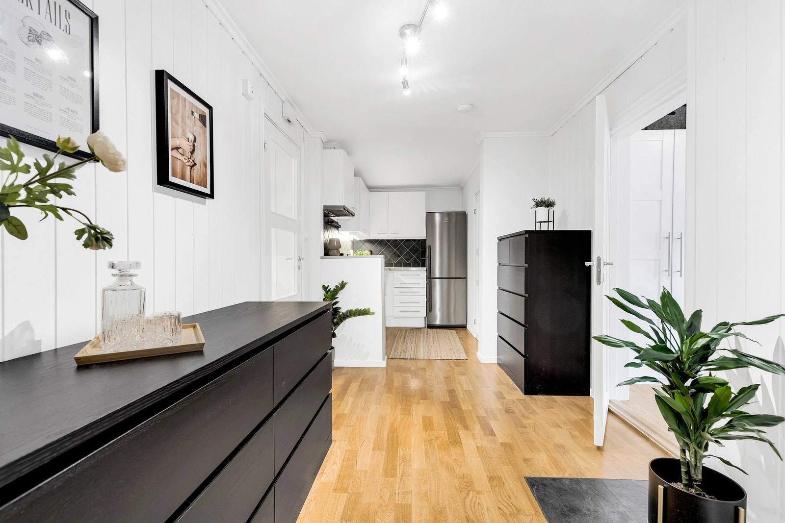 I gangen mellom stuen og kjøkkenet er det gode muligheter for å sette opp kommoder for ekstra lagringsplass. Galleribilde