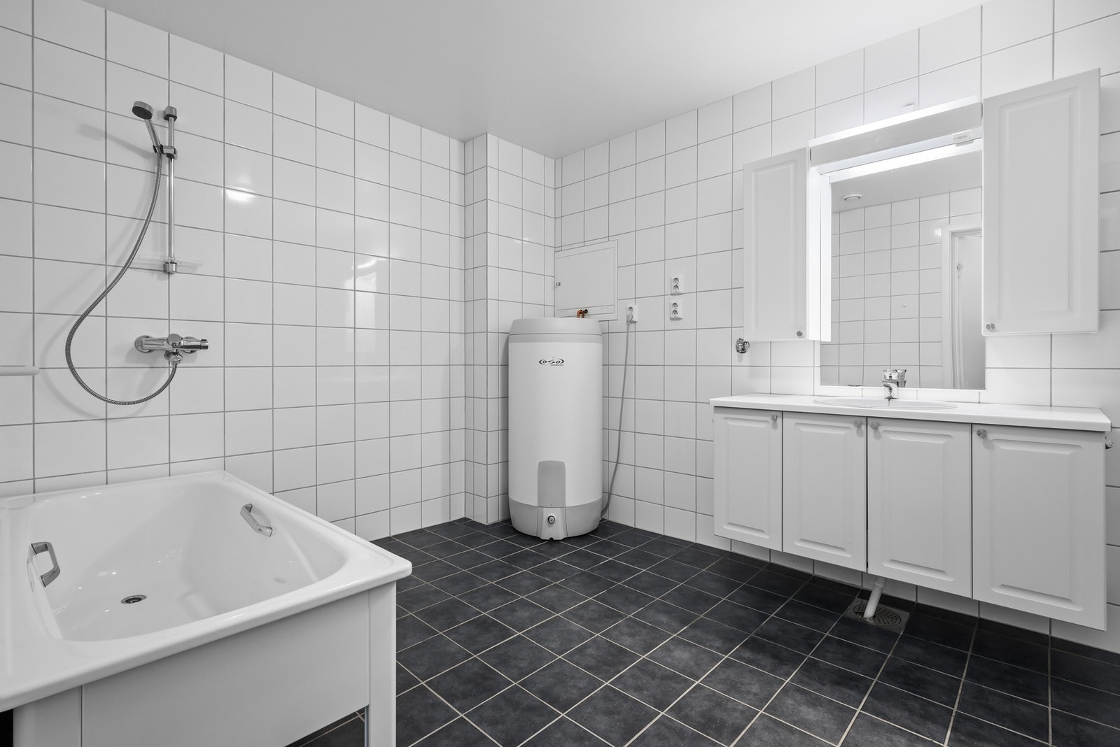 Badet har gulvvarme, opplegg for vaskemaskin og badekar. Galleribilde