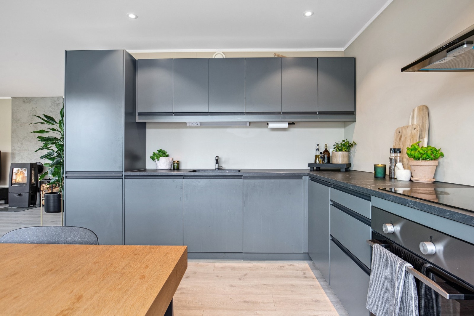 Flott kjøkken med over og underskap og integrerte hvitevarer Galleribilde