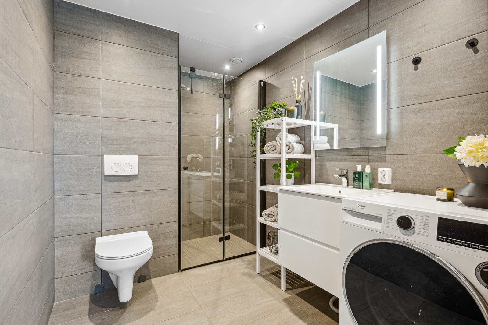 Delikat bad med innredning og nedfelt servant, vegghengt wc og dusjnisje Galleribilde