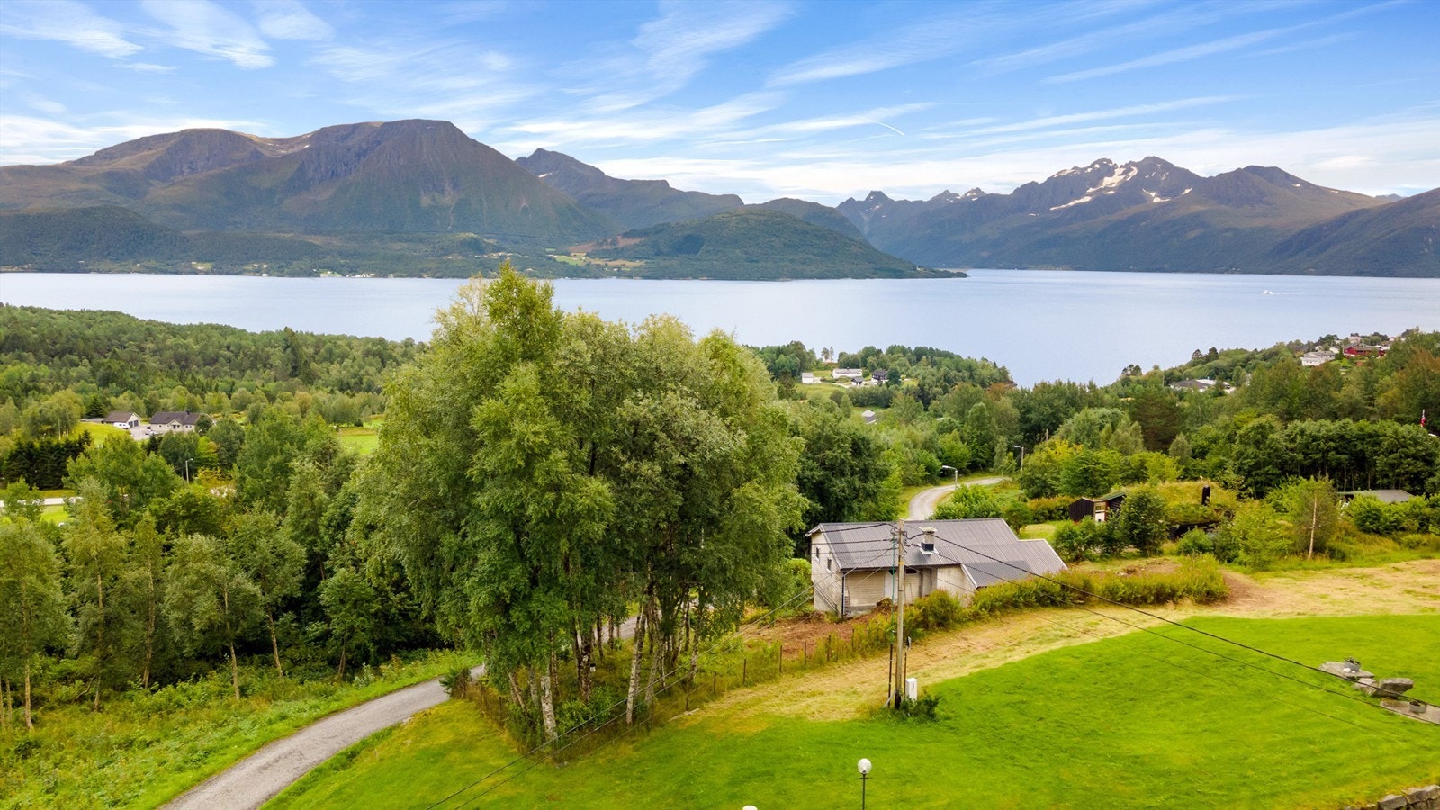 Dronebilde tatt fra nord mot syd med flott utsikt over fjord og fjell Galleribilde