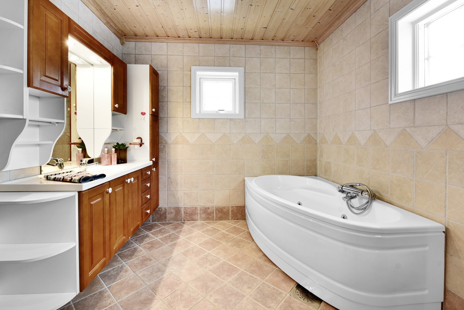 Stort, flislagt bad med servantskap og badekar Galleribilde