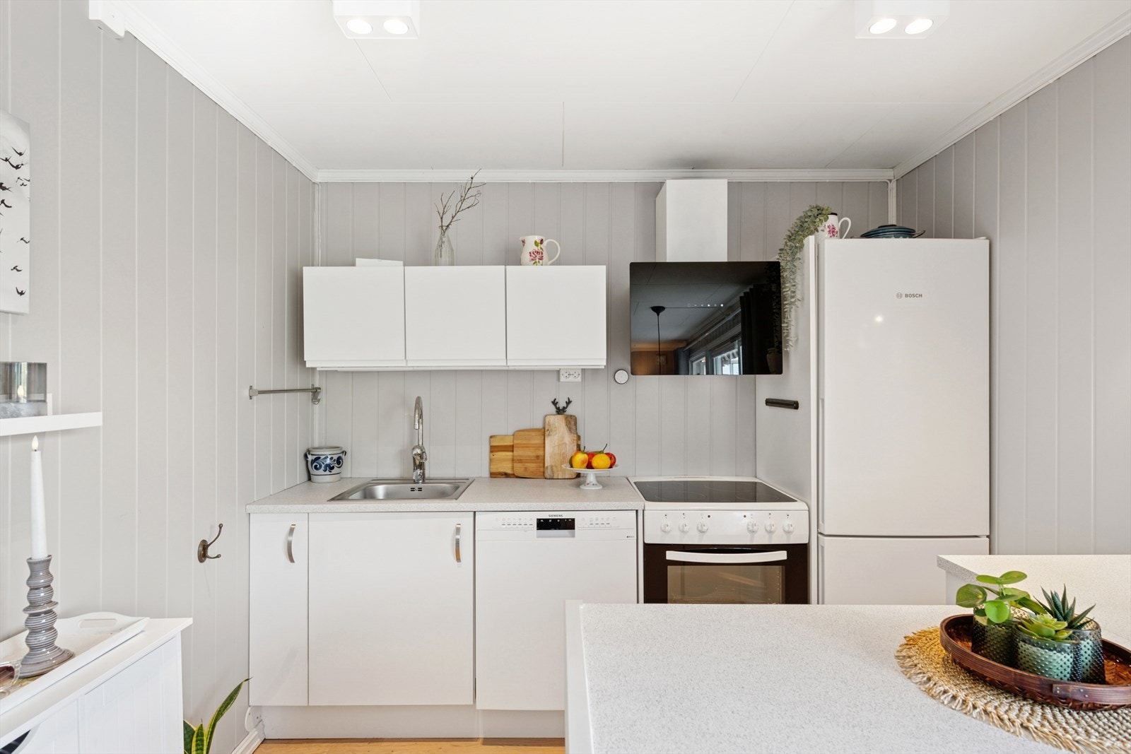 Kjøkkenet har innredning med glatte fronter og benkeplaten av laminat. Videre er kjøkkenet utsyrt med kjøl/fryseskap, oppvaskmaskin og komfyr. Galleribilde