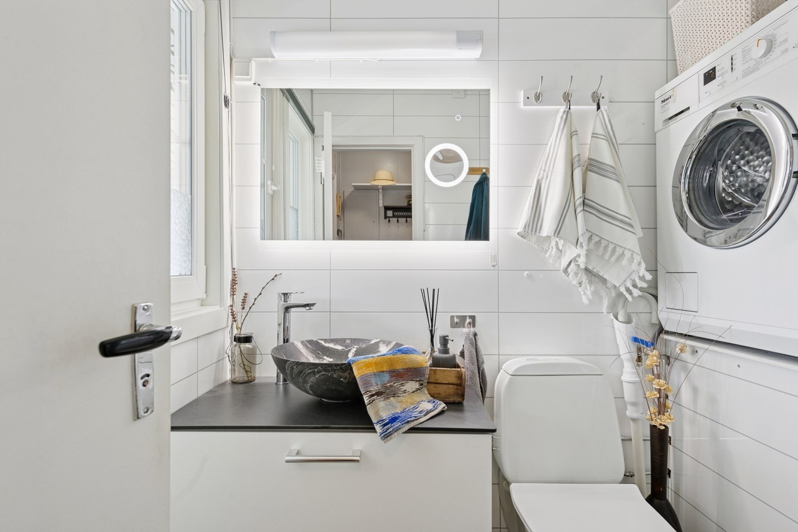 Eldre baderomsinnredning med servant, dusjkabinett og opplegg for vaskemaskin. Galleribilde