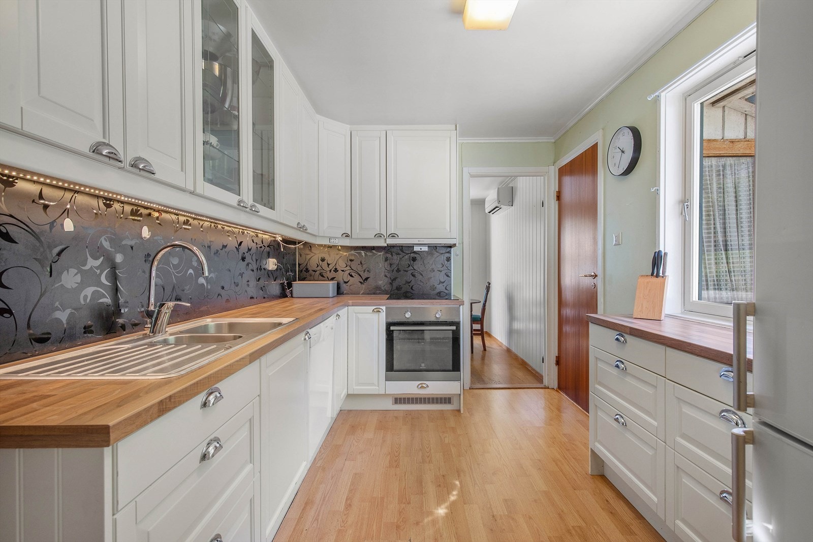 Kjøkenet har innredning med profilerte fronter, benkeplate i laminat med nedfelt benkebeslag med dobbel kum Galleribilde