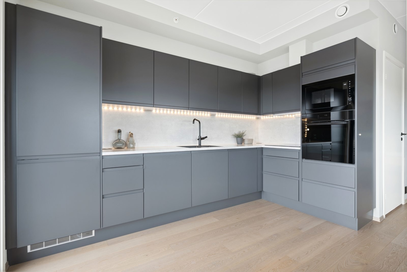 Kjøkkenet har stilfull innredning med glatte fronter og laminat benkeplate. Galleribilde