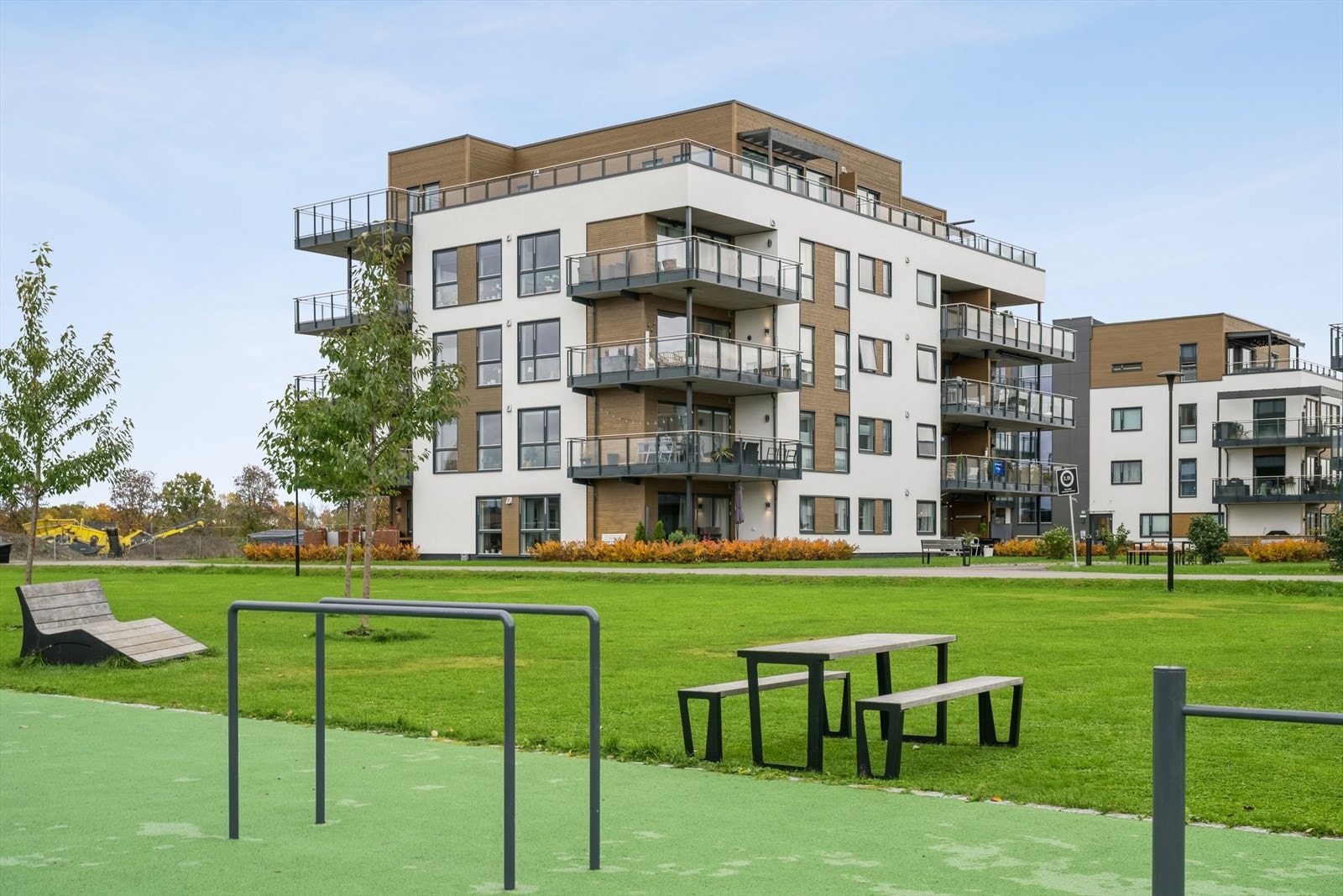 Pent opparbeidet fellesareal med benk og ulike lekeapparater Galleribilde