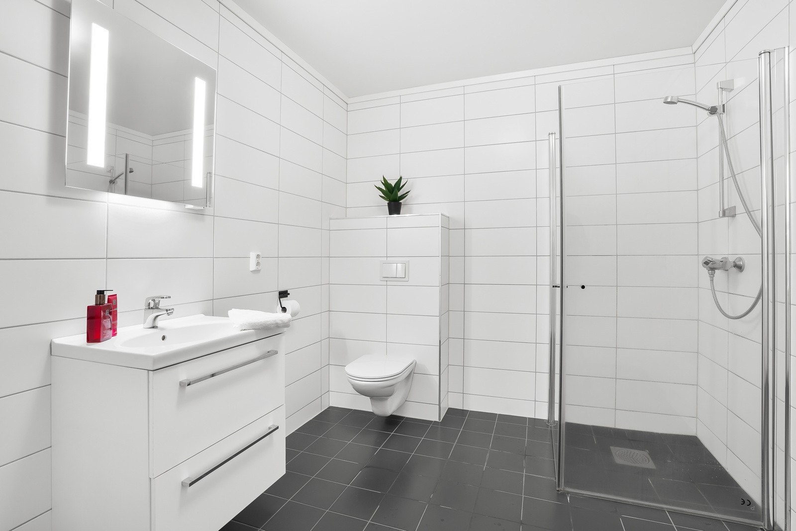 Badet har flislagt gulv og vegger, varmekabler og balansert ventilasjon. Galleribilde