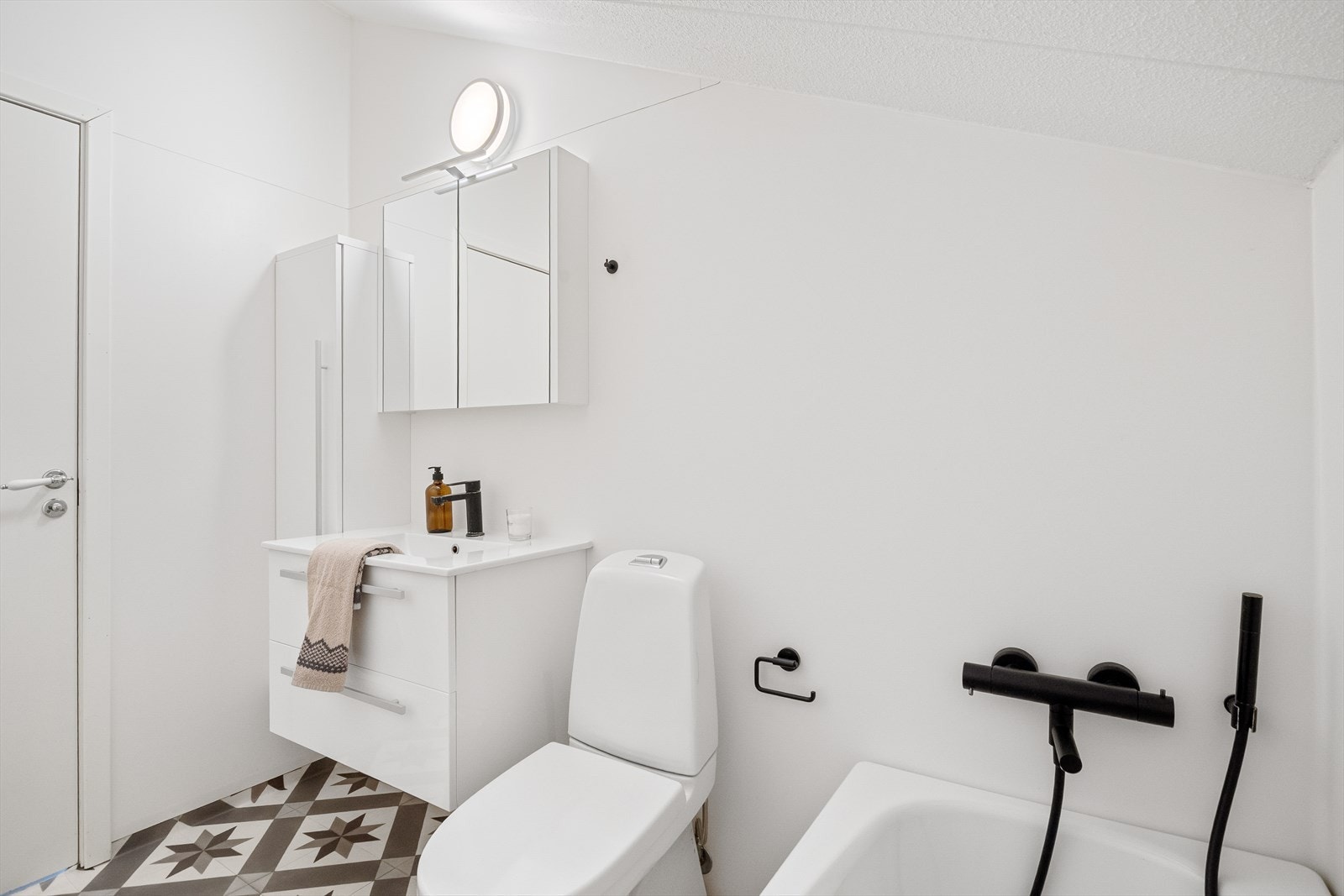 Innredet med servant i baderomsmøbel, speilskap, toalett og badekar. Galleribilde