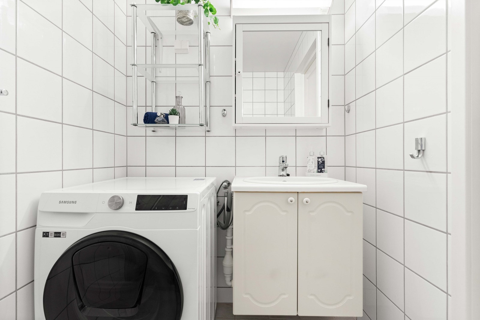 Vegghengt servantskap med nedfelt servant og ett-greps armatur. Det er også opplegg for vaskemaskin. Galleribilde