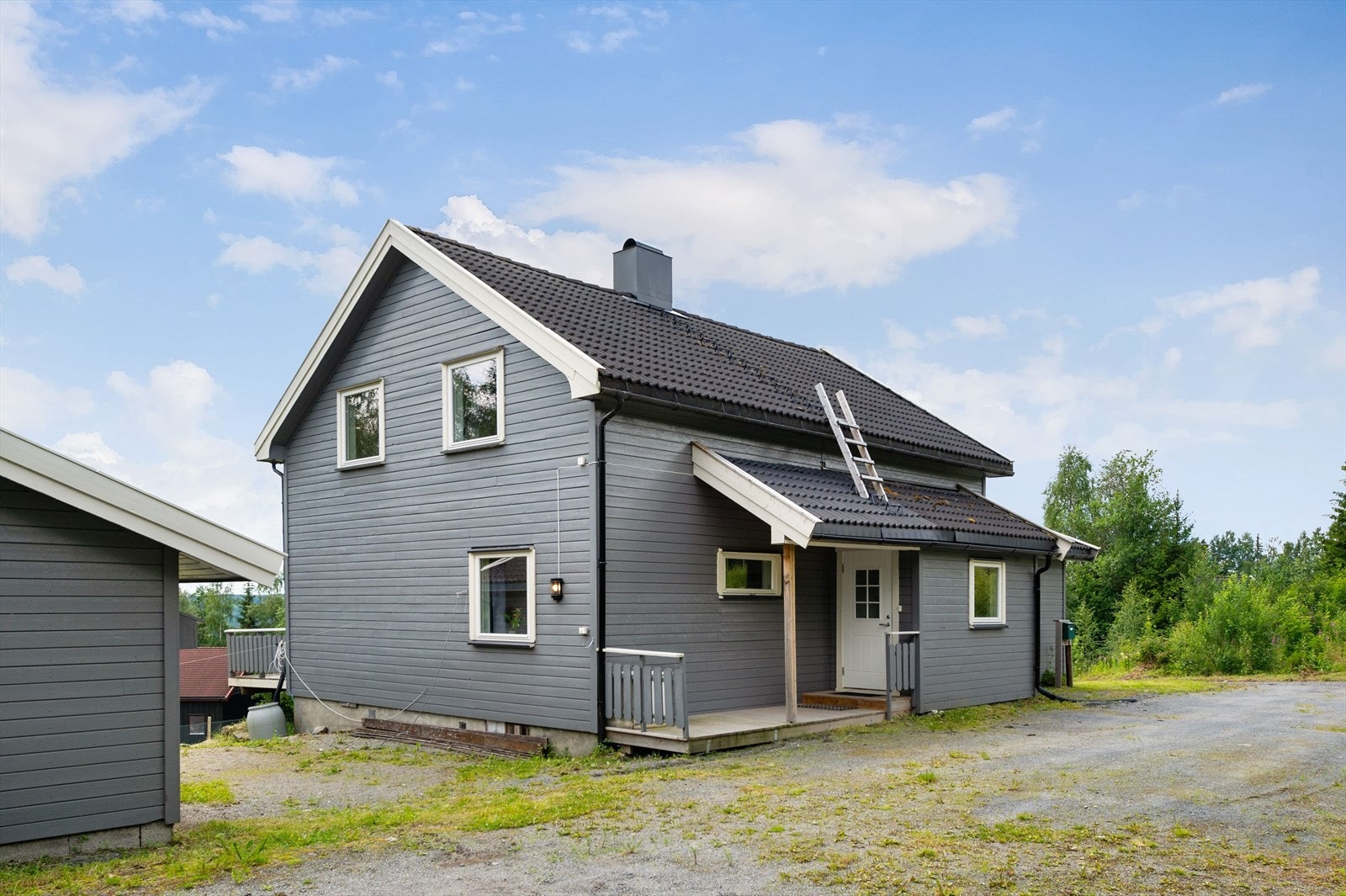 Tomten er flat/skrånende og opparbeidet med plen og beplantning. Gruset/asfaltert gårdsplass. Galleribilde