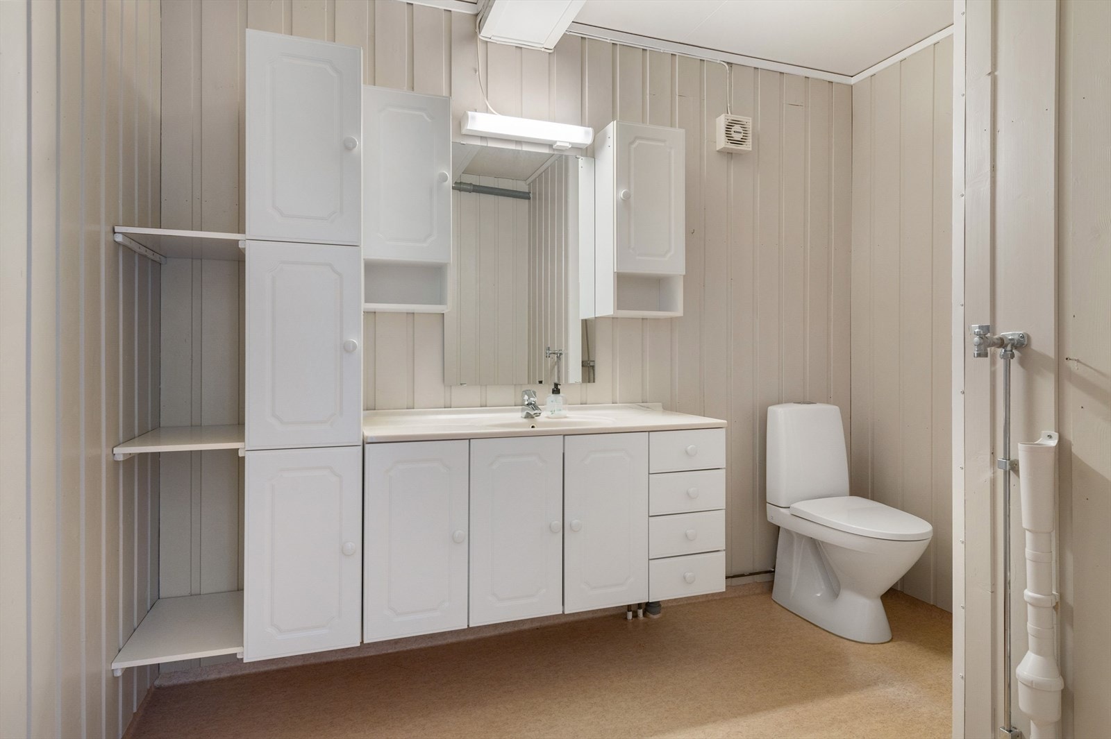 I tilknytning til soverommet i 1. etasje er det et lyst baderom med belegg på gulv, overflater med malt panel kombinert med våtromsplater og mekanisk avtrekk. Galleribilde