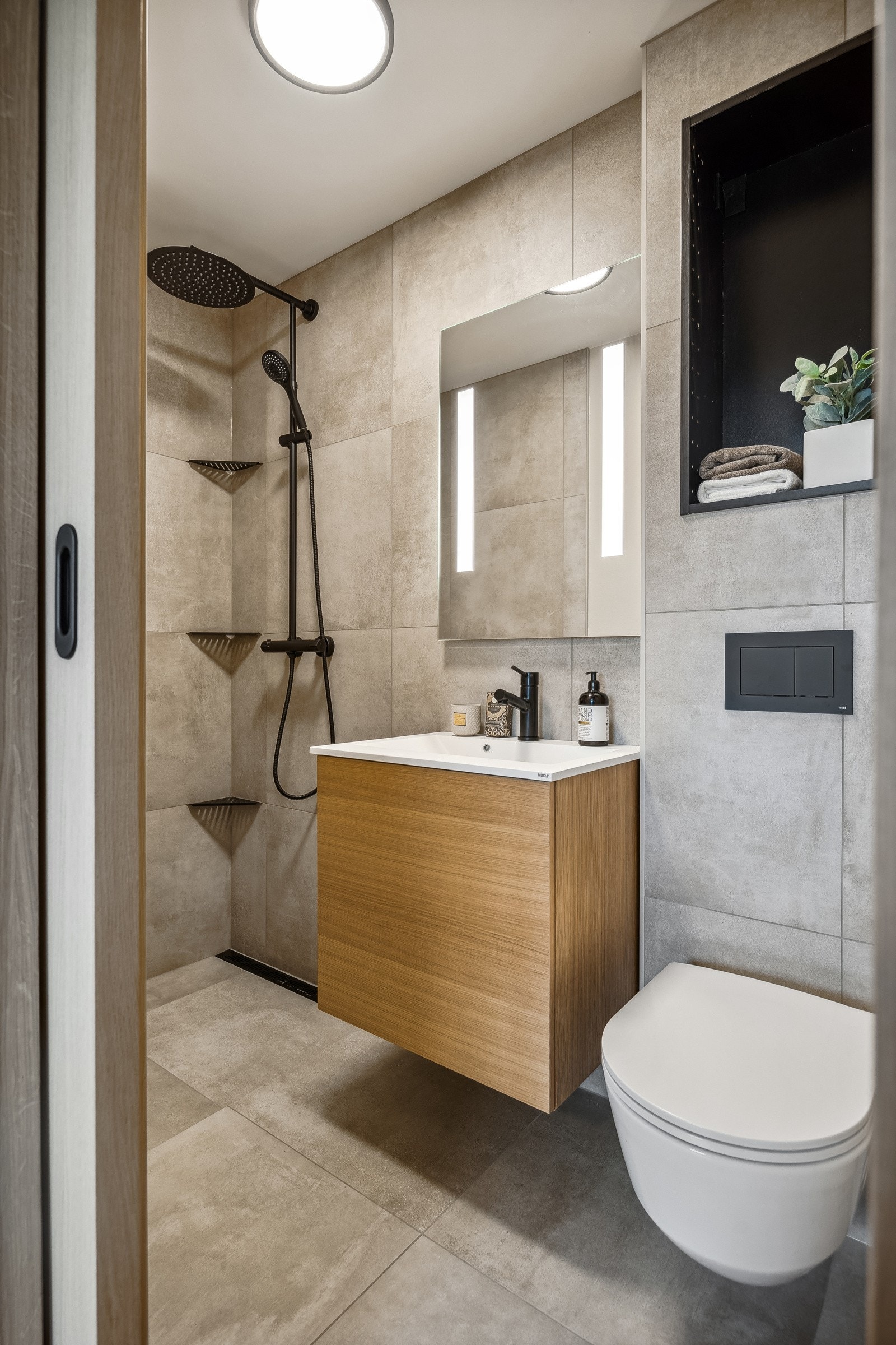 Baderommet måler ca. 3 kvm og er innredet med servant med underskap, dusjhjørne og vegghengt toalett. Galleribilde