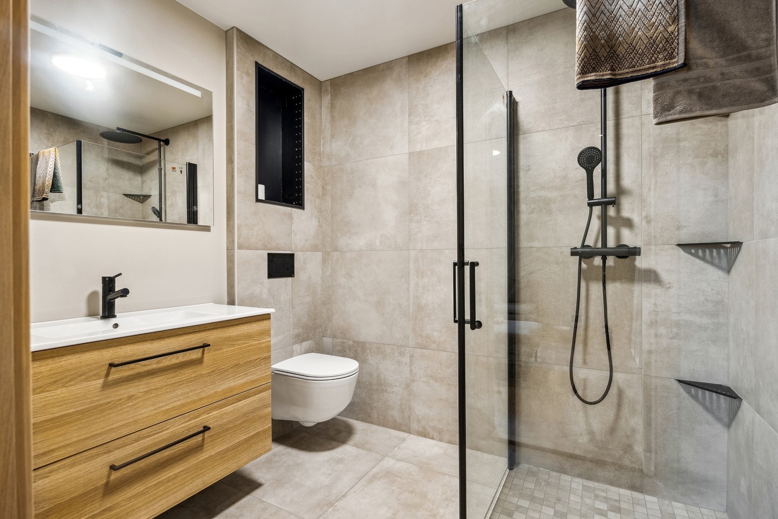 Baderommet er moderne og har en innredning bestående av servant med underskap, dusjhjørne med foldbare dører og vegghengt toalett. I denne etasjen finner vi også et vaskerom på hele 19 kvm. Galleribilde