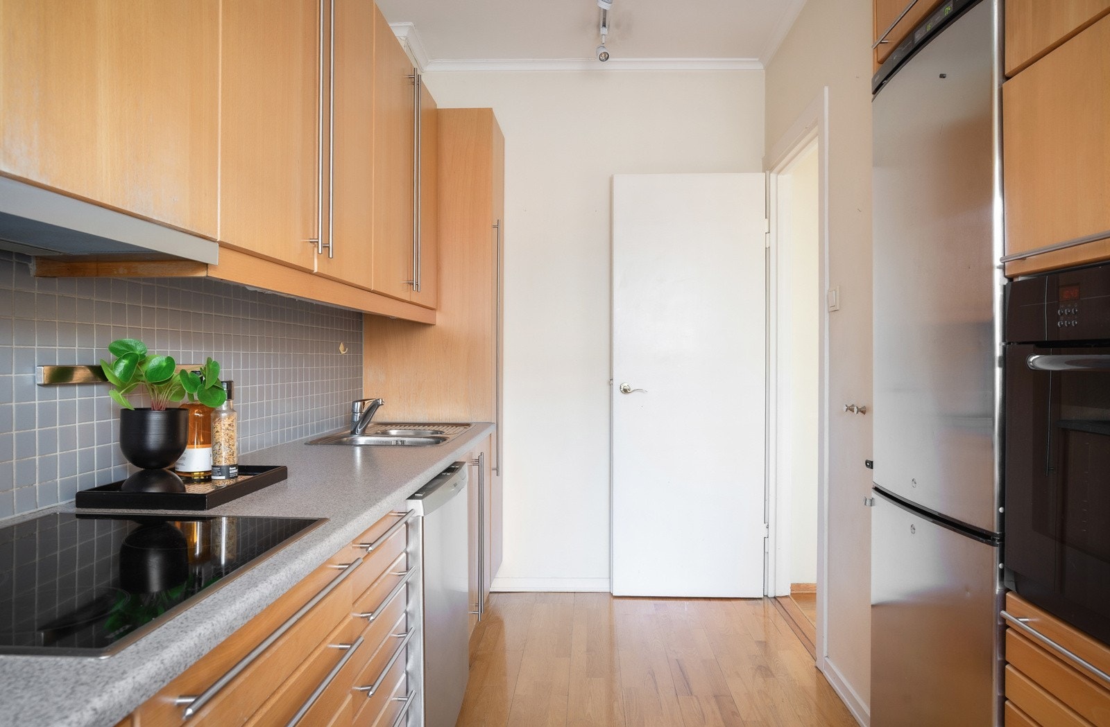 Kjøkkeninnredningen har glatte fronter i bøk og folierte benkeplater med nedfelt kum i rustfritt stål Galleribilde