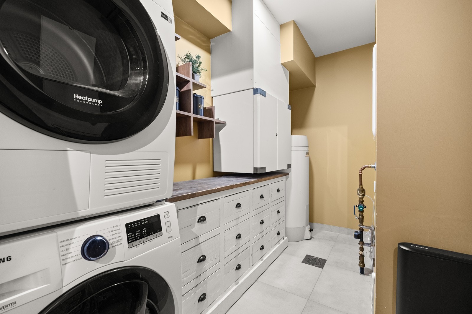 Praktisk vaskerom med flislagt gulv og varmekabler Galleribilde