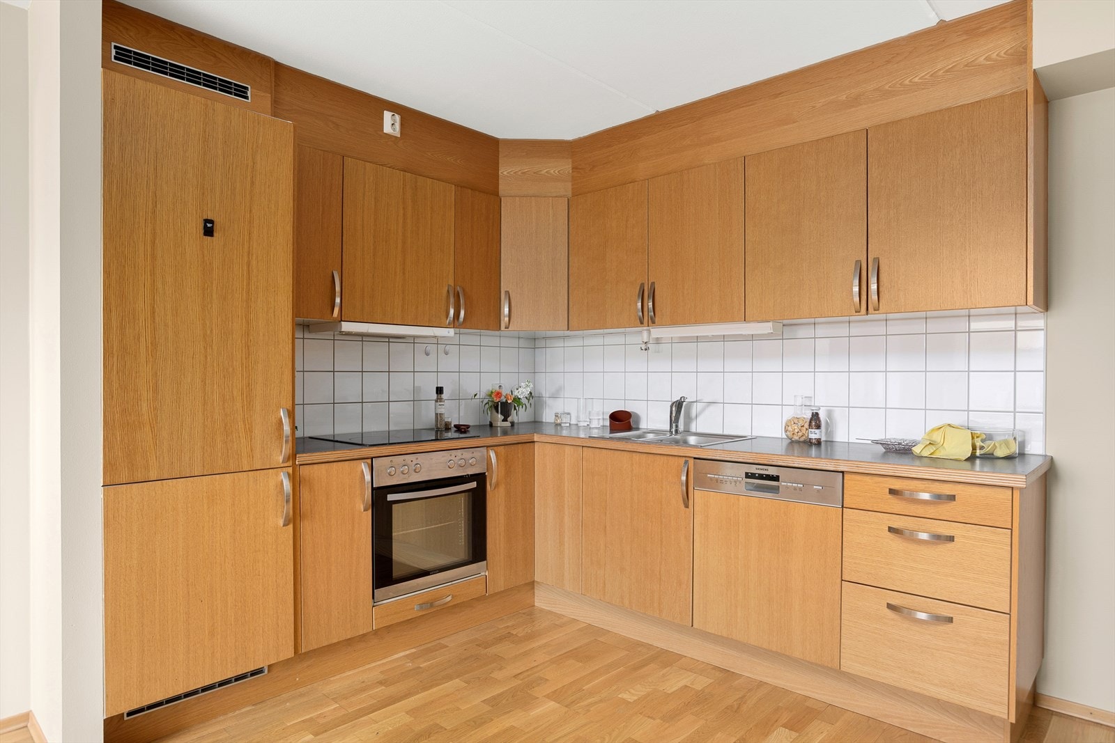 Tidløs og pen kjøkkeninnredning med integrert stekeovn, platetopp, kjøl/frys og oppvaskmaskin Galleribilde