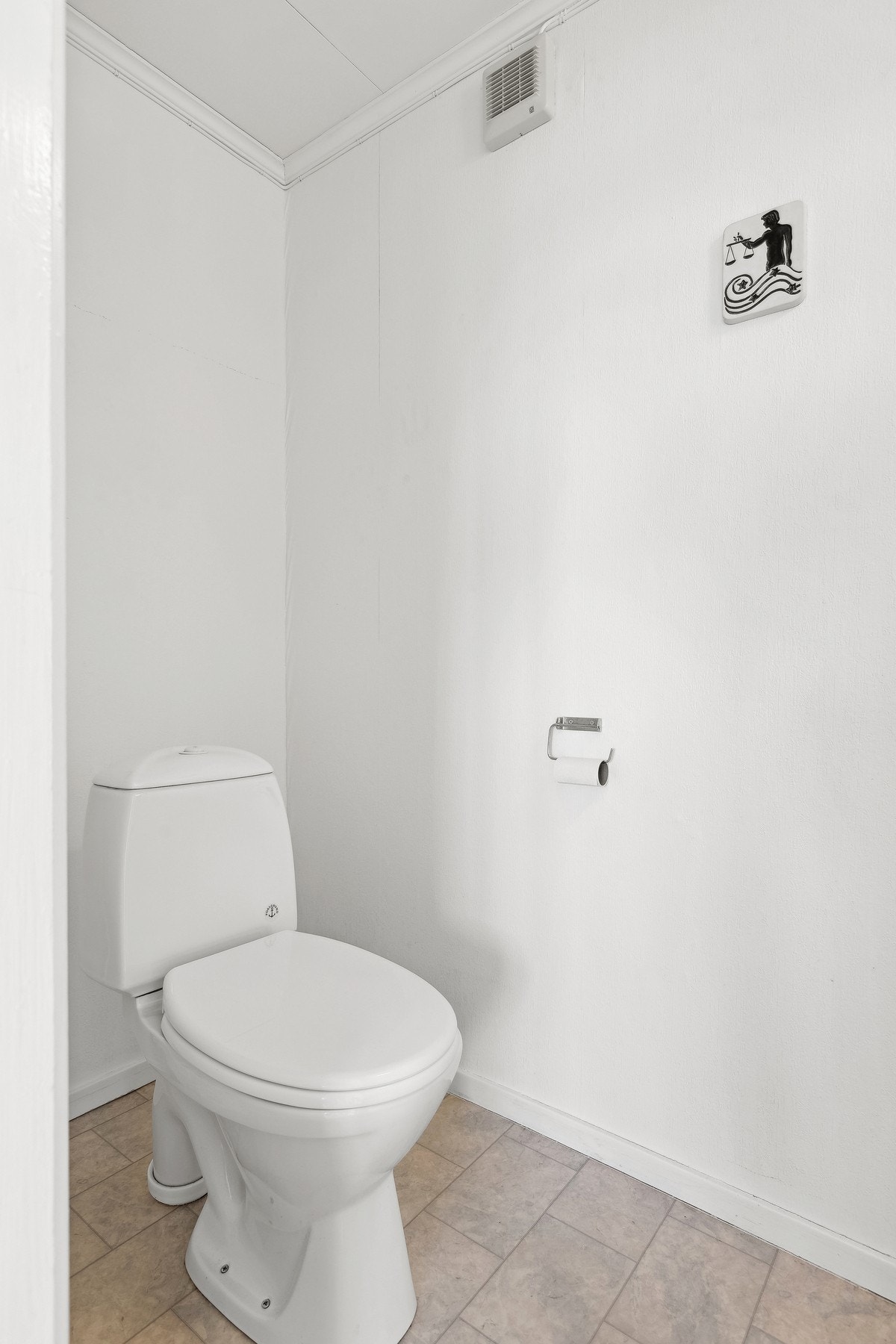 Separat toalett med praktisk gulvbelegg, tapetserte vegger og tak-ess plater i himlingen. Galleribilde