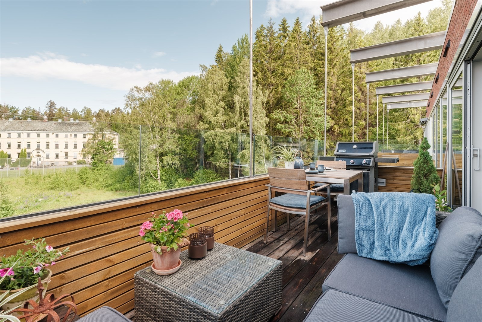 Balkongen har treverk med liggende spiler og med klart sikkerhetsglass. Galleribilde