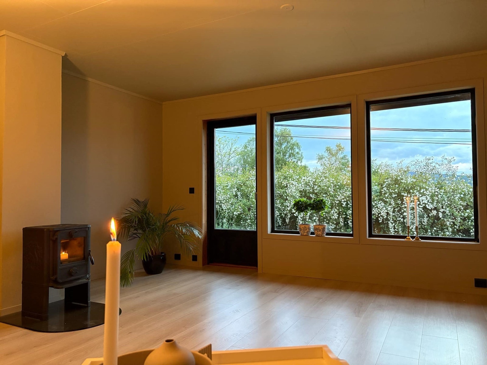 Romslig stue med store vinduer som slipper inn naturlig lys, og gir en vakker utsikt mot frodig natur. Galleribilde