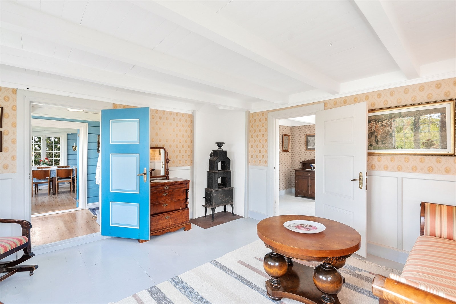 Det er adkomst til stuen fra trappehallen og soverommet. I stuen står det i dag en flott etasjeovn som ikke er i bruk etter tilsyn fra brannvesen. For å kunne benytte seg av begge pipeløpene i stuen og kjøkkenet, må pipene rehabiliteres. Galleribilde