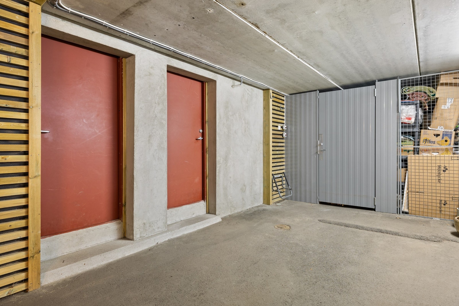 Rød dør lengst bort - inn til boligens underetasje via sluse med oppbevaringsmulighet/hylleseksjon. Galleribilde