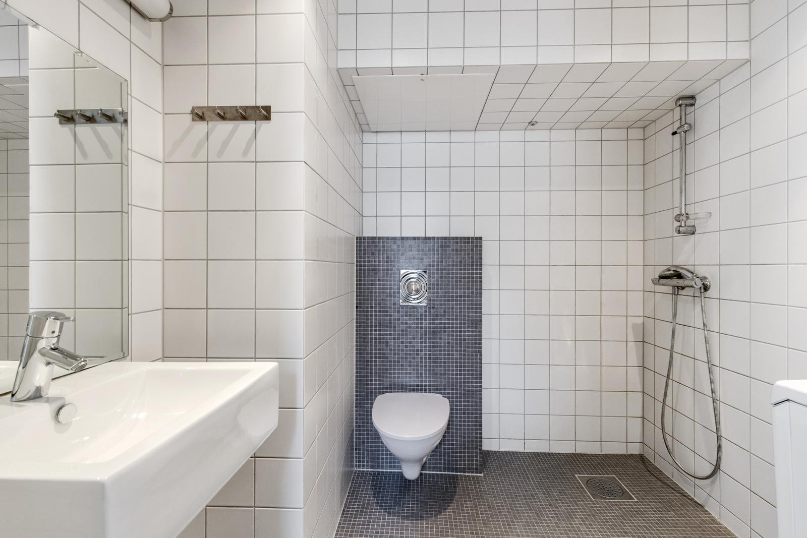 Flislagt bad med wc, servant, dusjhjørne og vaskemaskin Galleribilde