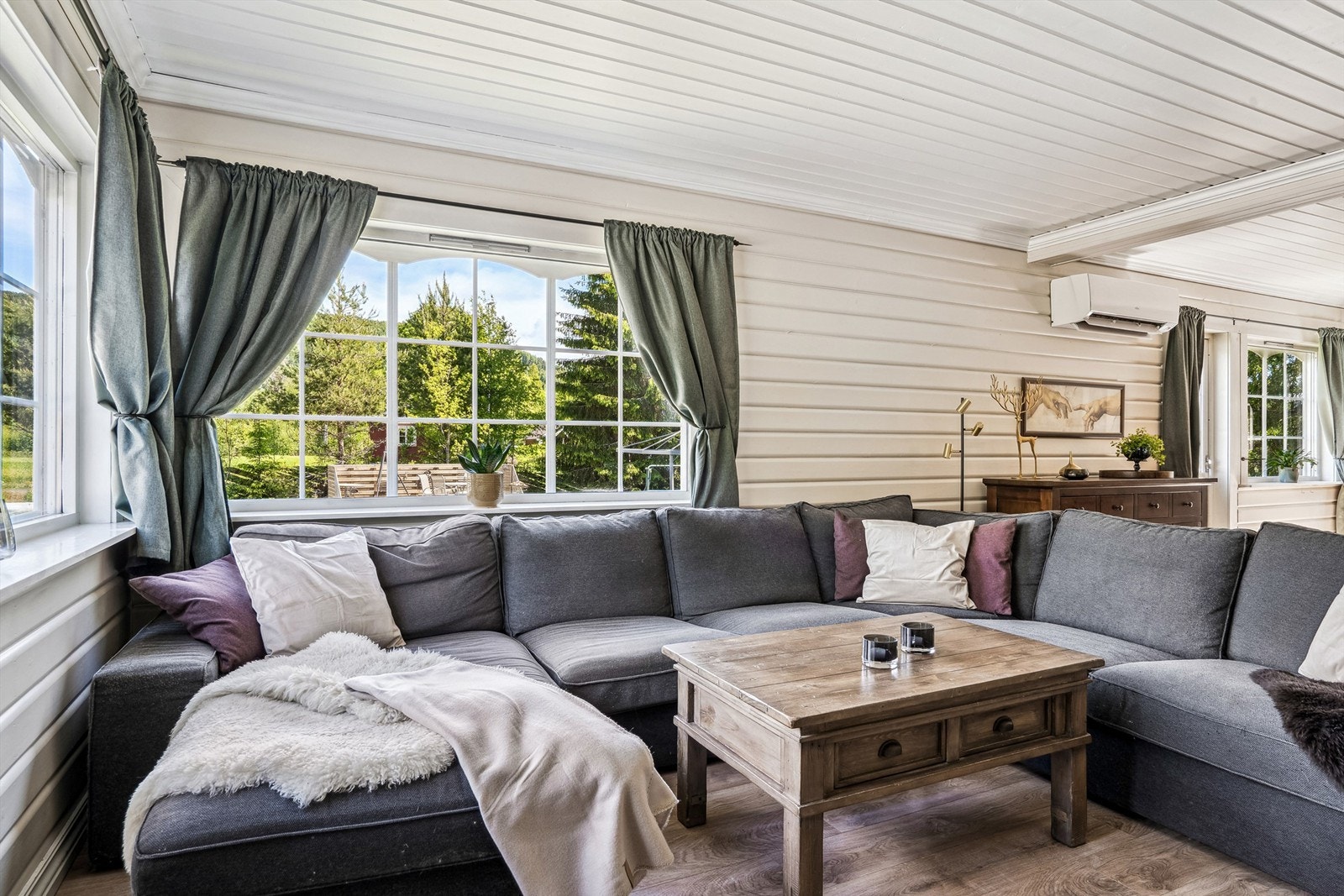 Romslig stue med store vinduer og mye lys Galleribilde