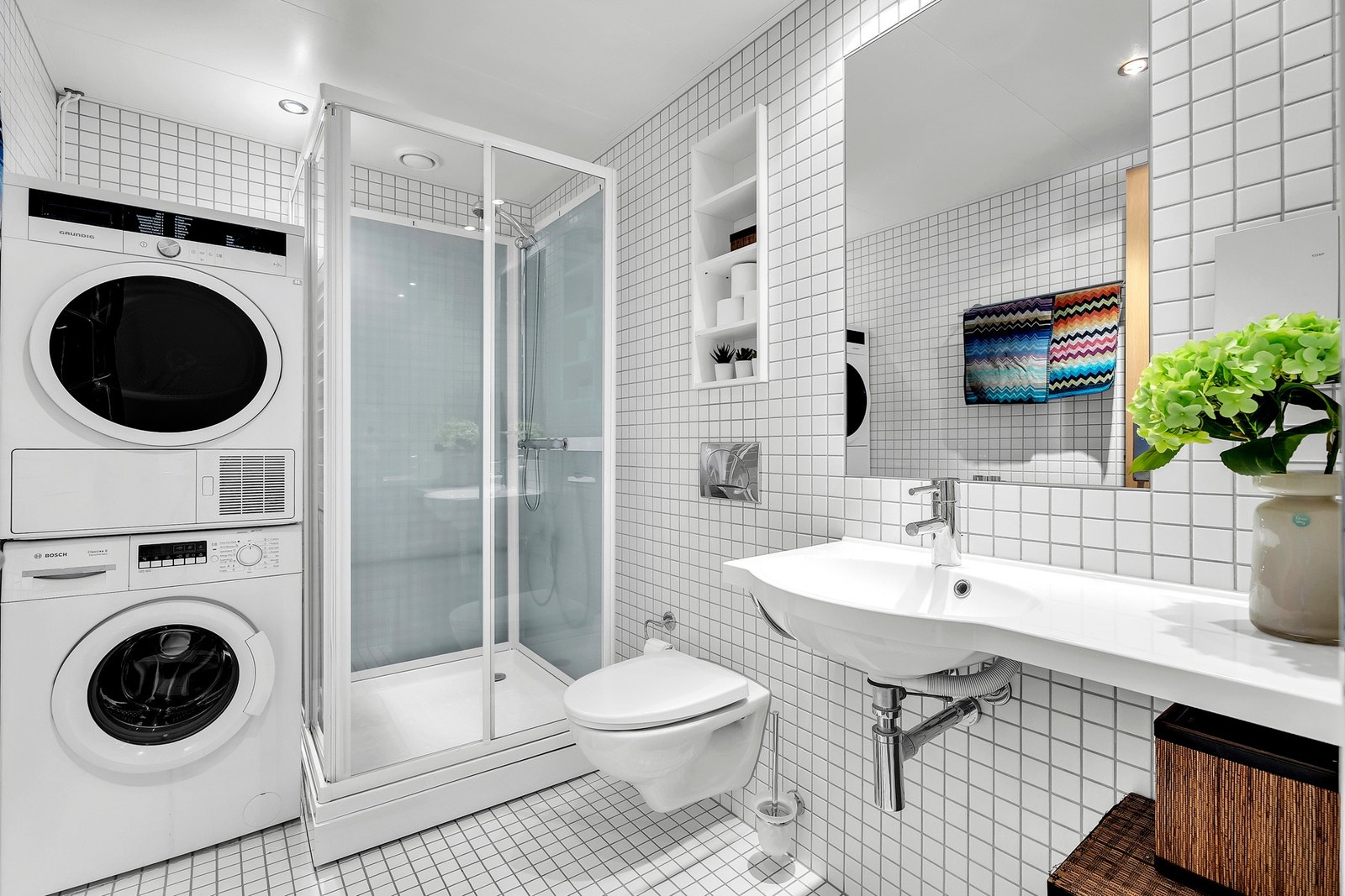 Badet har flislagte gulv og vegger, samt himlingsplater i taket, som gir et rent og tidløst uttrykk. Galleribilde