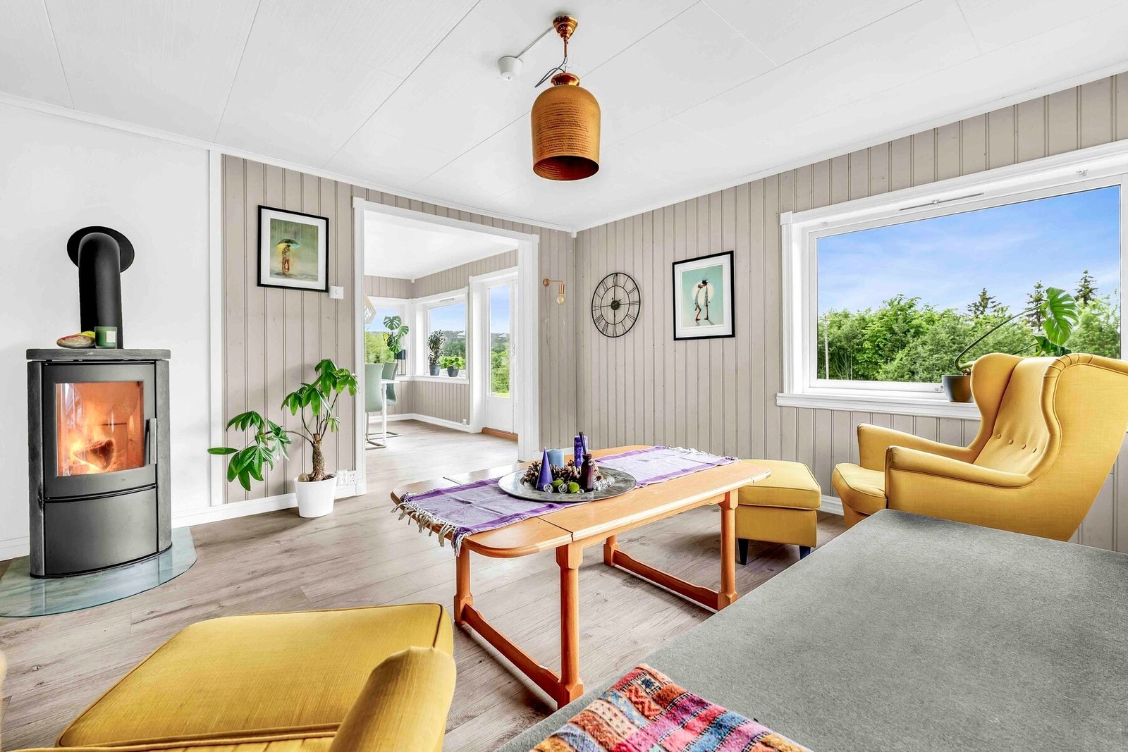 Meget koselig stue med store vinduer og peisovn Galleribilde