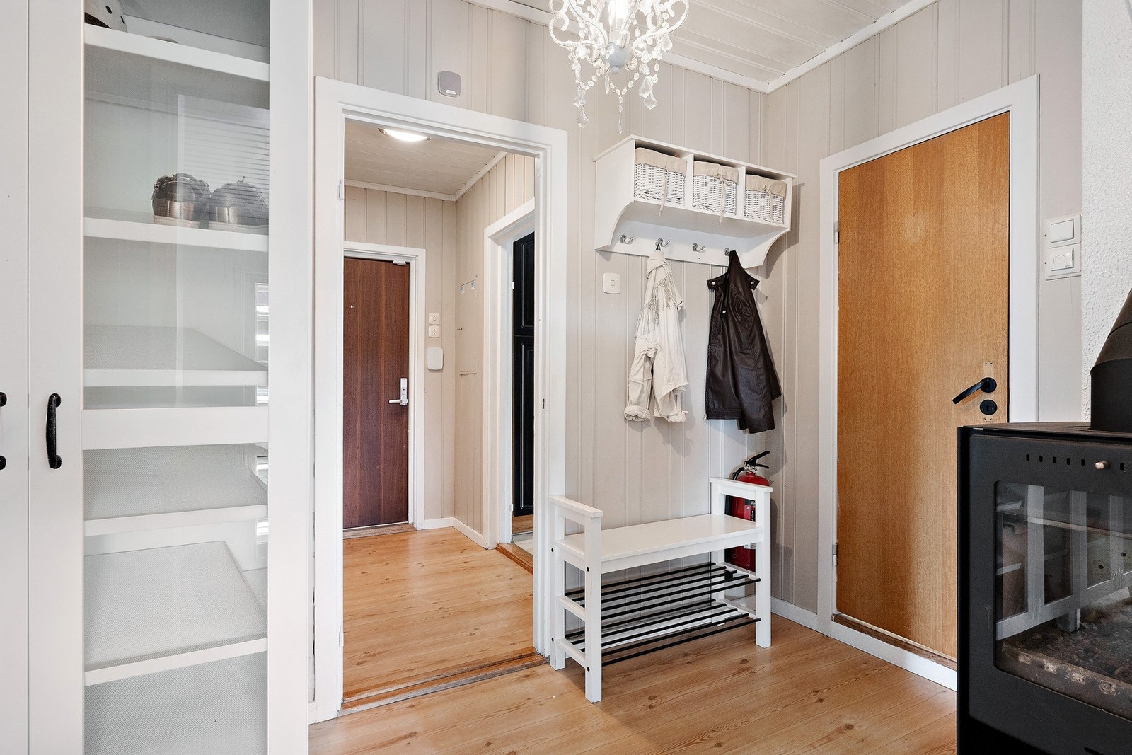 Vel innenfor døren er det en pen entré med lysmalt panel på veggene, videre inn er det en romslig gang med bl.a. en vedovn i støpejern fra Jøtul. Galleribilde