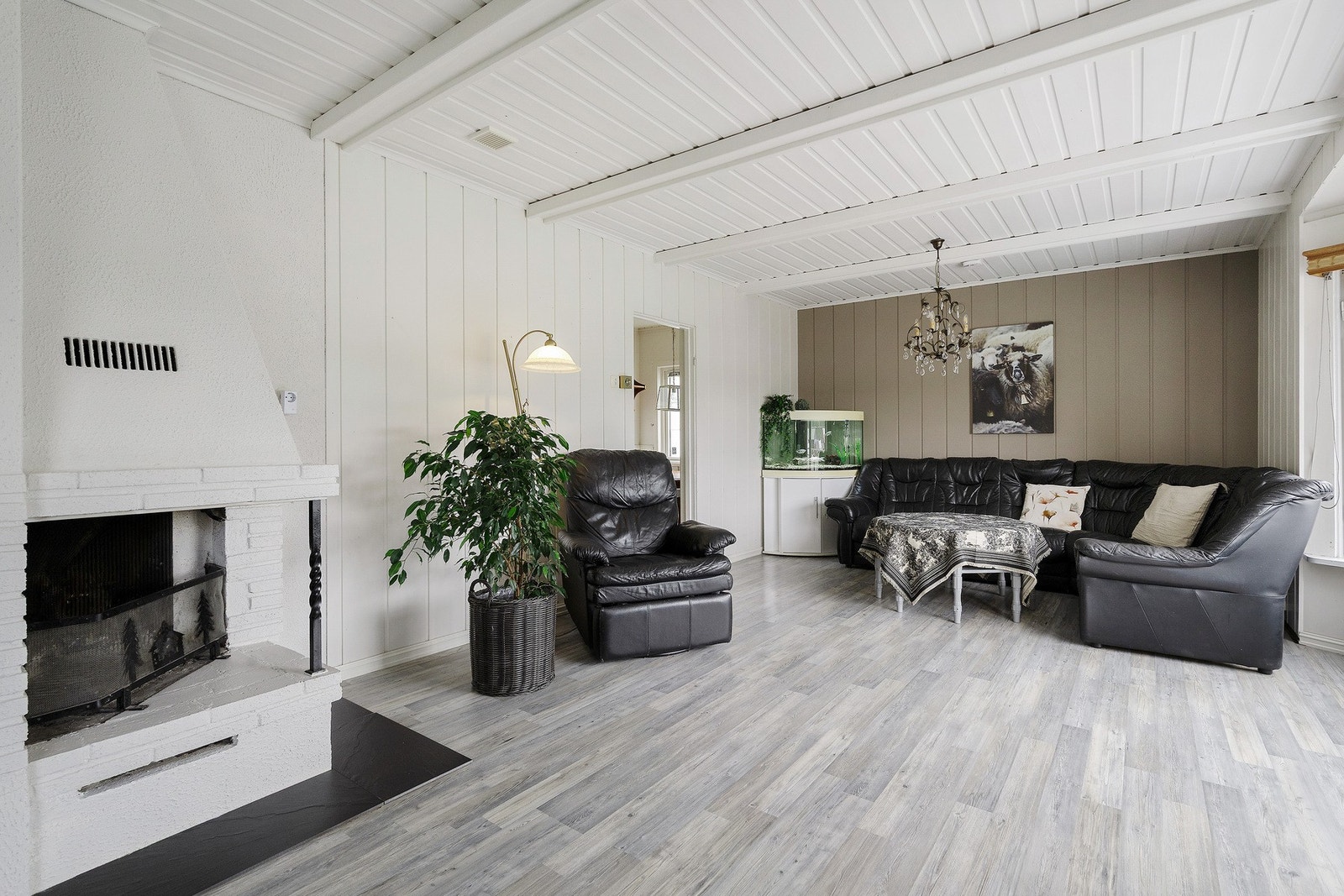 Sentralt i stuen er det en oppmurt, åpen peis for varme og hygge på kjøligere dager. Galleribilde