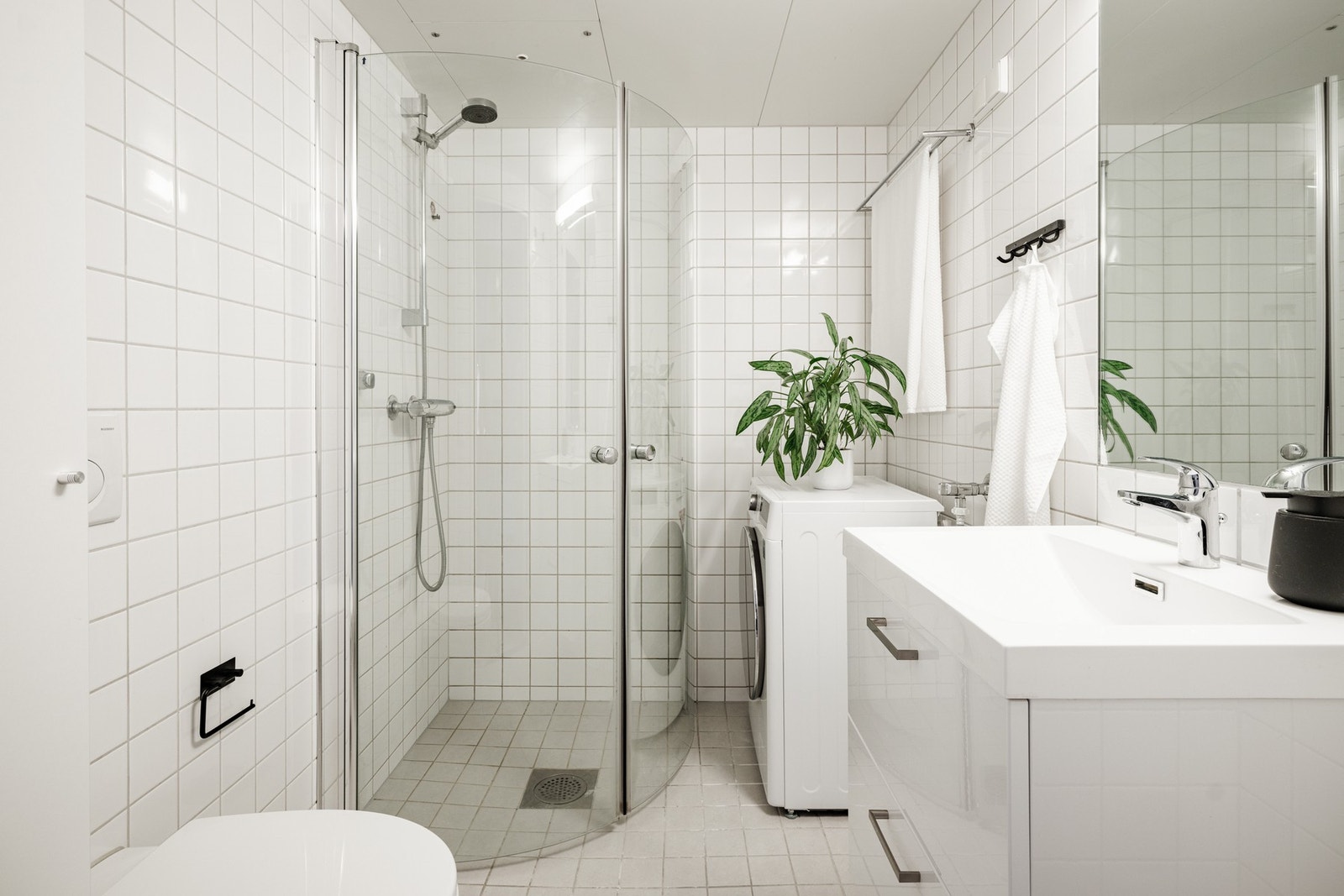 Stort og pent baderom med opplegg for vaskemaskin. Galleribilde