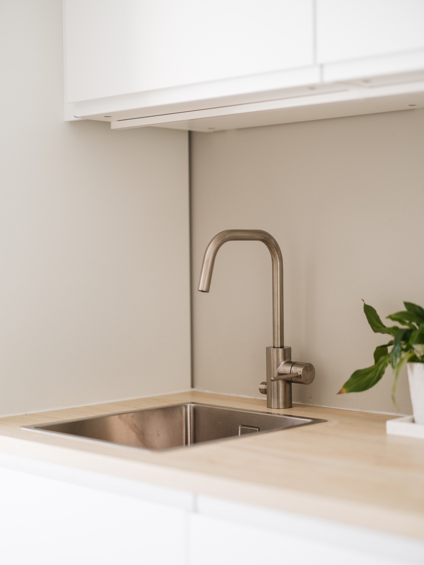 Malt flate mellom benkeplate samt overbelysning og stikkontakter under overskap. Galleribilde