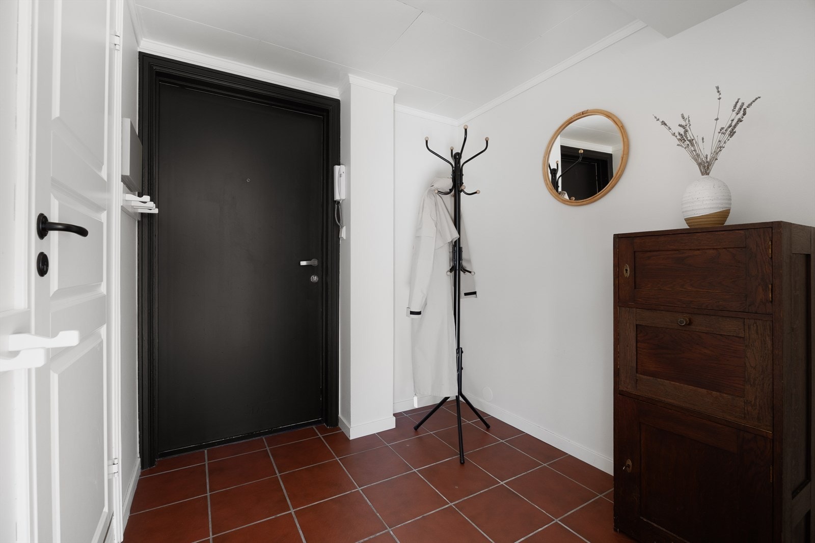 Det første som møter deg i leiligheten er en innbydende og praktisk flislagt entré. Her slipper du enkelt inn gjestene fra gateplan med dørtelefonen. Galleribilde