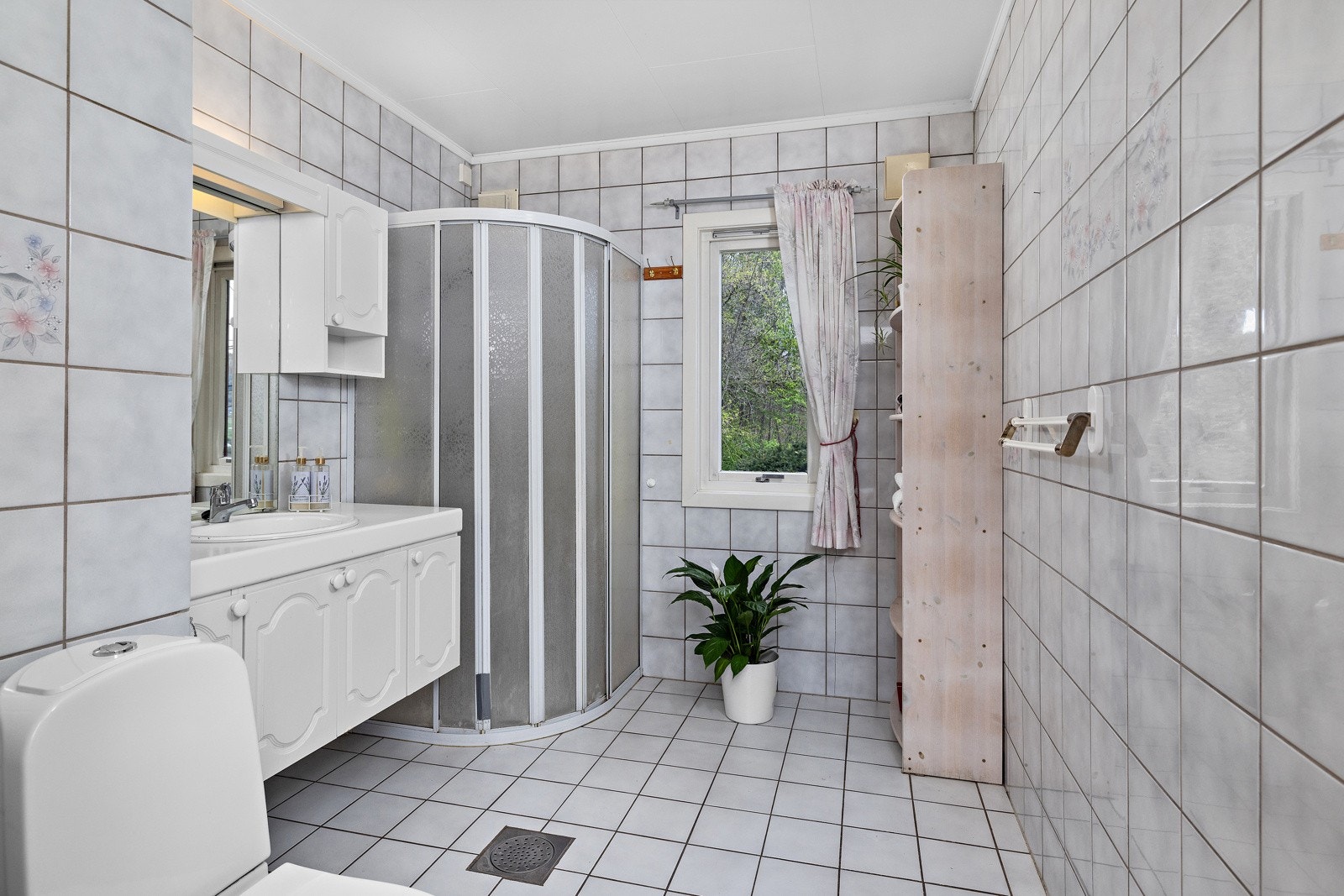 Romslig og flislagt bad med fin beliggenhet til soverommene i huset. Badet har varmekabler i gulvet. Galleribilde