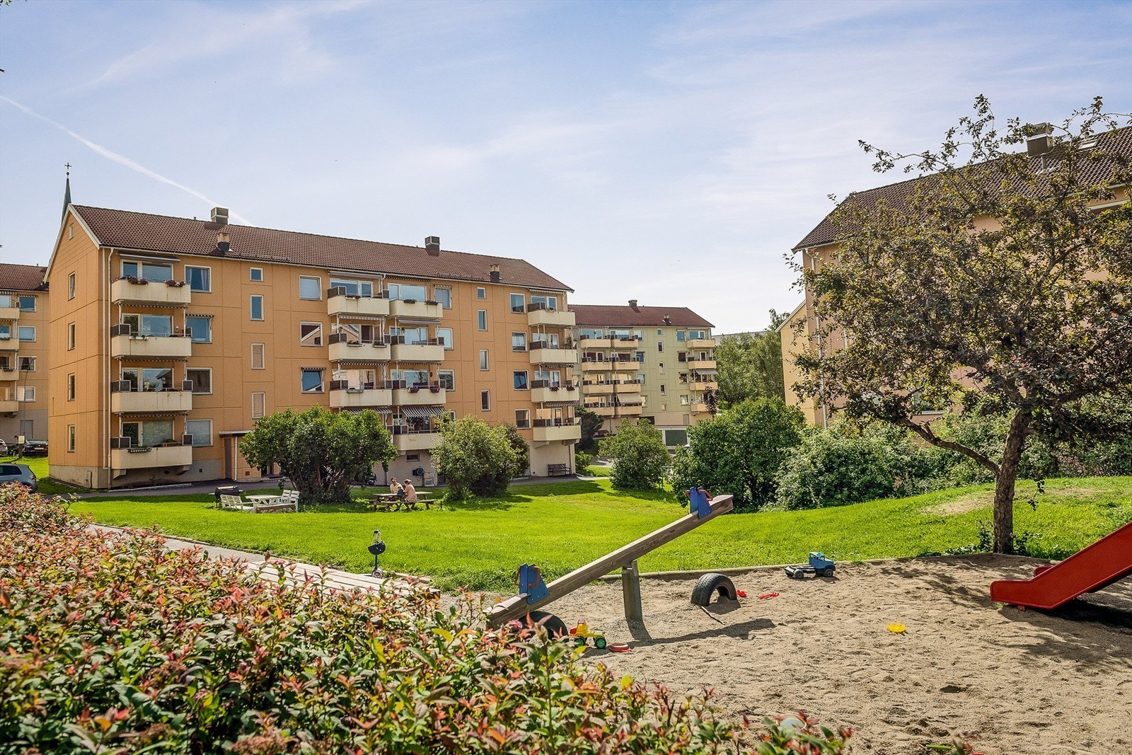 På forsiden av blokken er det satt ut sittegruppe som innbyr til grilling, mens barna sparkesykler eller hopper paradis Galleribilde