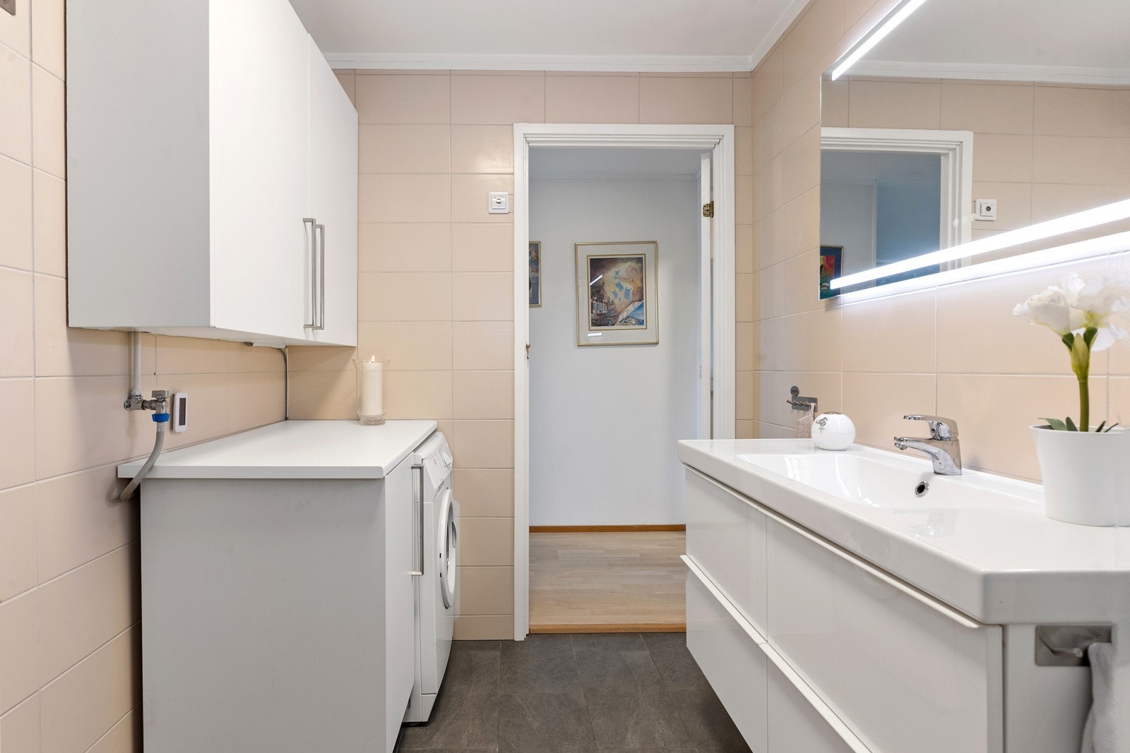 Badet er utstyrt med toalett, servant med skap og dusjkabinett. Galleribilde
